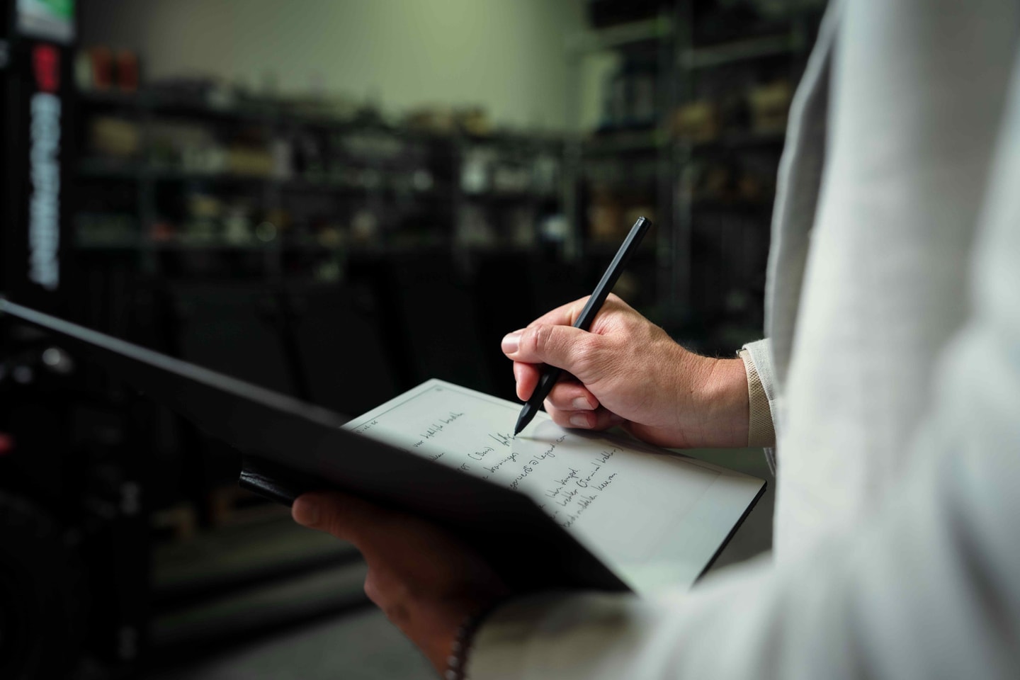 Hand schrijft met een pen notities op een klembord